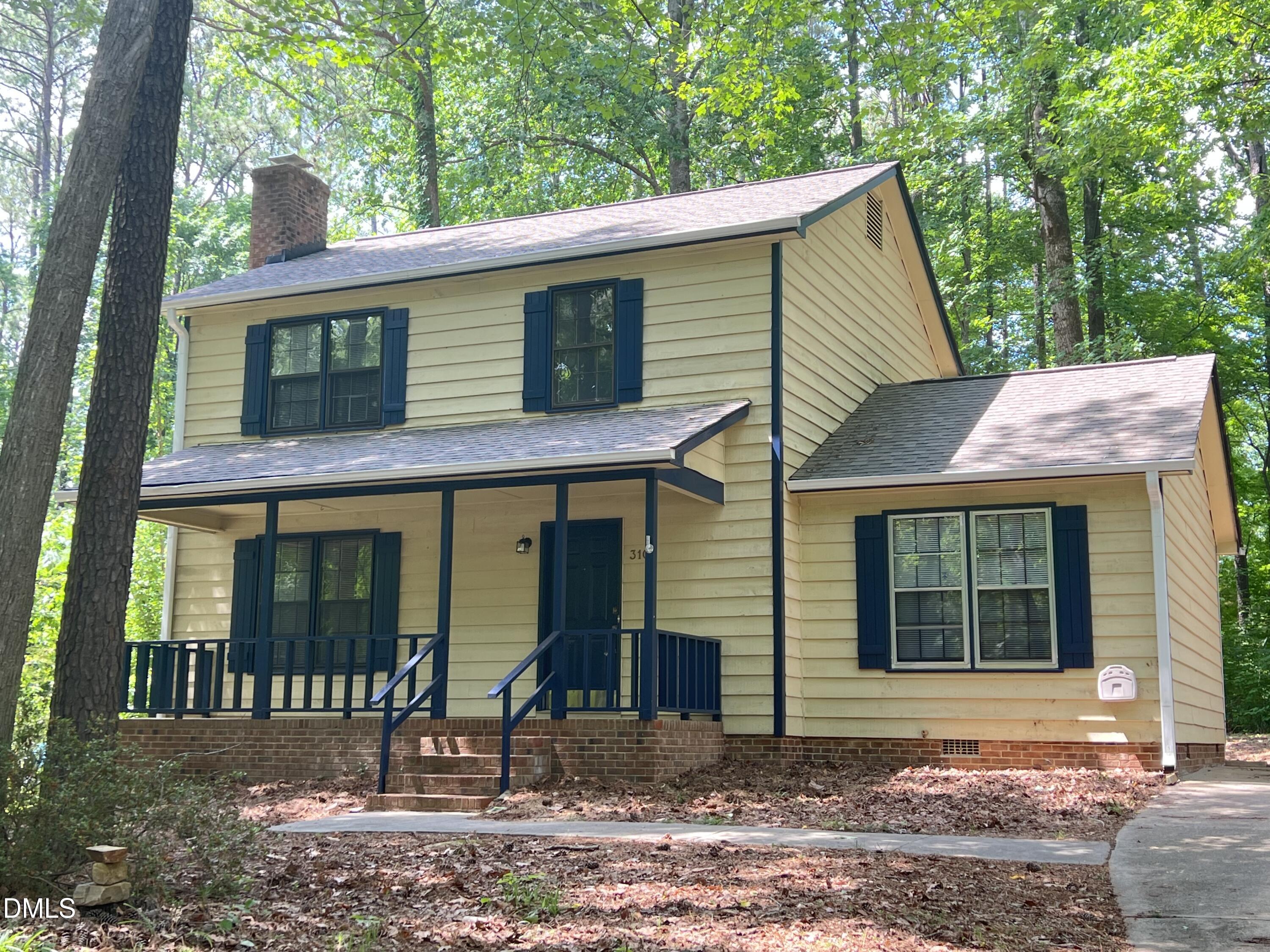 a view of a house with a yard and large tree