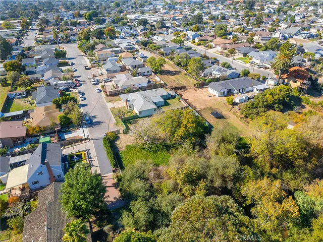 an aerial view of residential houses with outdoor space and trees