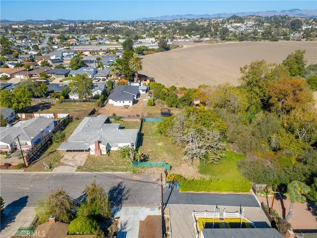 an aerial view of residential houses with outdoor space and ocean view