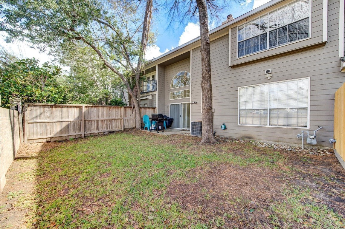 14420 Walters Road, Unit 58 Houston, TX 77014 - Photo 23 of 25 a view of a backyard with large trees and wooden fence