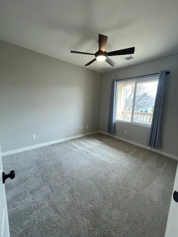 an empty room with chandelier fan