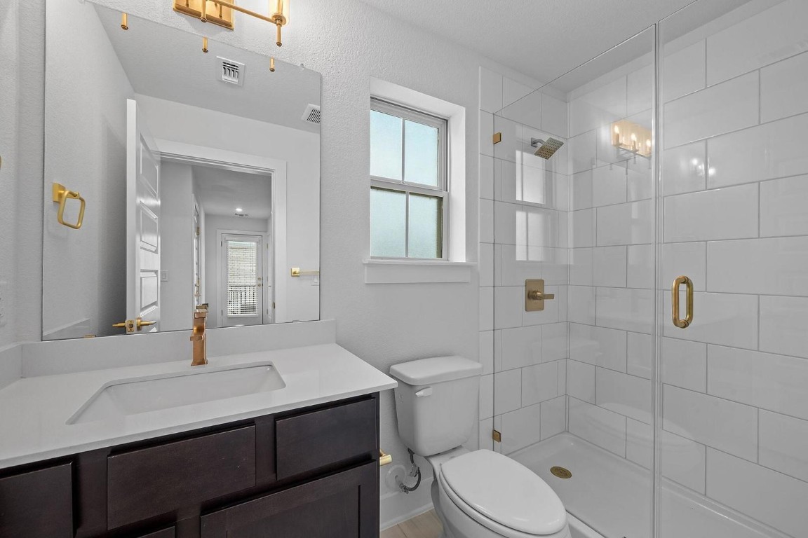 6312 Stockman Drive, Unit 5 Austin, TX 78747 - Photo 27 of 40 a bathroom with a sink toilet a mirror and shower