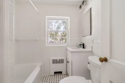 a bathroom with a sink toilet and window