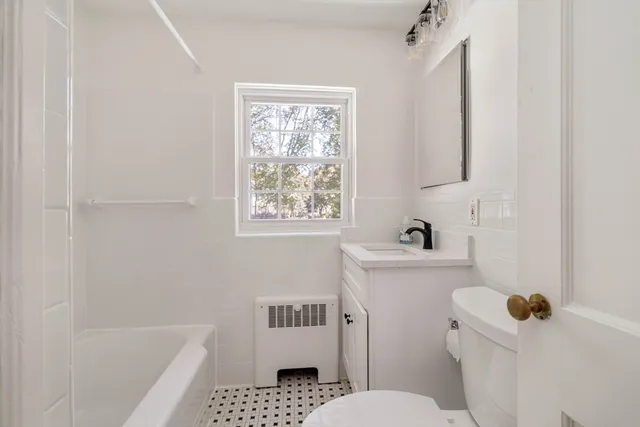 a bathroom with a sink toilet and window