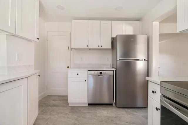 a white refrigerator freezer and a stove sitting inside of a kitchen with granite countertop cabinets