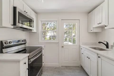 a kitchen with a sink stove and microwave