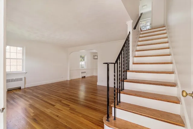 a view of entryway and hall with wooden floor