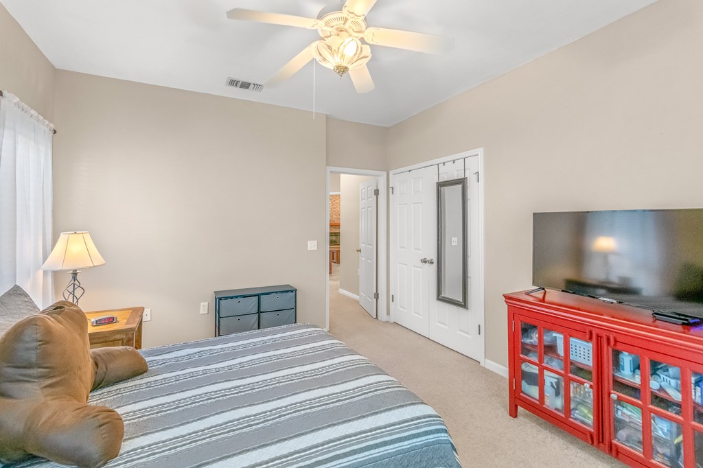 225 Los Cedros Loop Kerrville, TX 78028 - Photo 20 of 27 a bedroom with a bed and a lamp