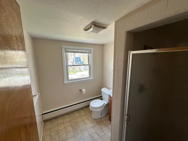 a bathroom with a granite countertop toilet and a sink