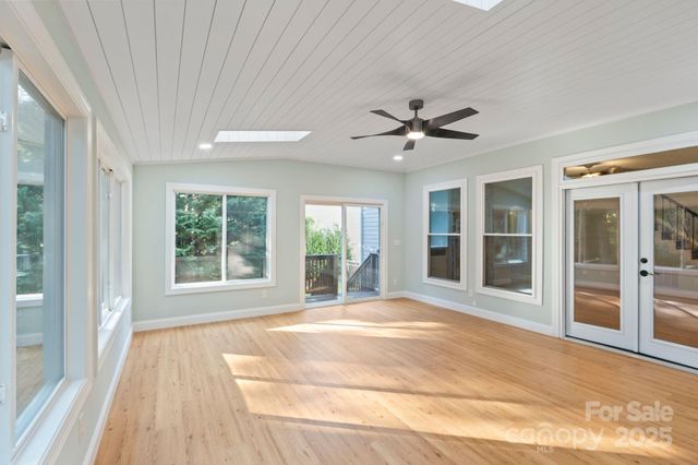 a view of an empty room with a window and a kitchen