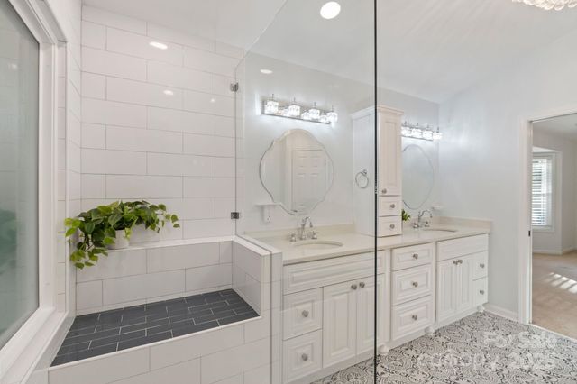 a bathroom with a sink double vanity mirror and bathtub