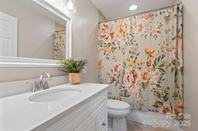 a bathroom with a granite countertop sink a toilet and a mirror