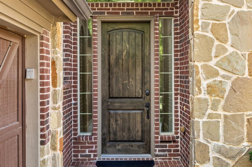 1567 Red Rock Canyon Road Frisco, TX 75036 - Photo 4 of 36 Knotty alder wooden door flanked by windows enhance brightness of entry
