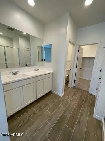 a spacious bathroom with a double vanity sink a mirror and a bathtub