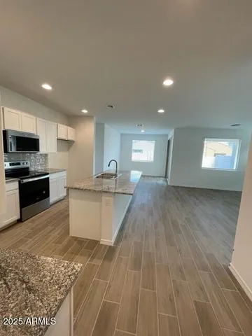 a large kitchen with kitchen island granite countertop a sink counter space and stainless steel appliances