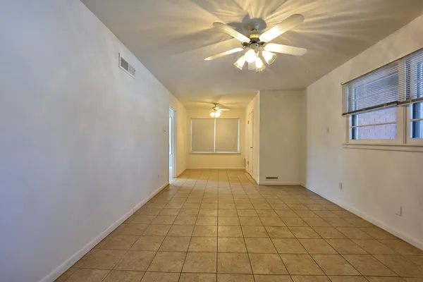 a view of an empty room with a chandelier fan