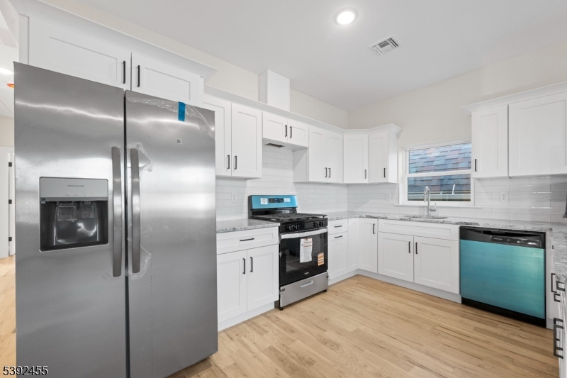 56 Second Street Elizabeth Port, NJ 07206 - Photo 12 of 28 a kitchen with cabinets stainless steel appliances and wooden floor