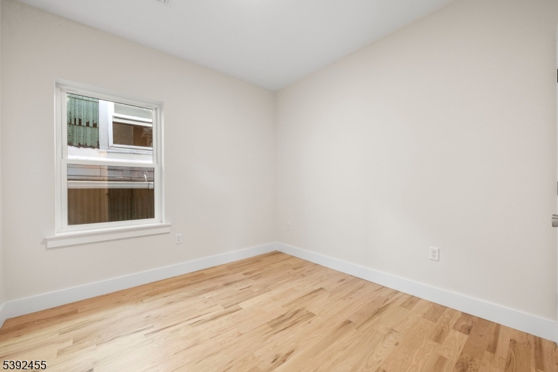 56 Second Street Elizabeth Port, NJ 07206 - Photo 13 of 28 a view of an empty room with wooden floor and a window