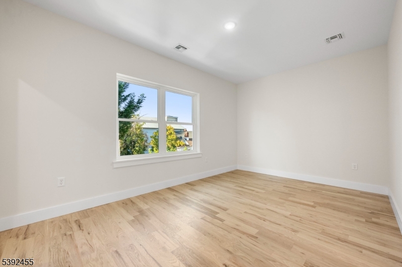 56 Second Street Elizabeth Port, NJ 07206 - Photo 27 of 28 wooden floor in an empty room with a window