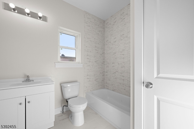 56 Second Street Elizabeth Port, NJ 07206 - Photo 5 of 28 a bathroom with a toilet a sink a mirror and a bathtub