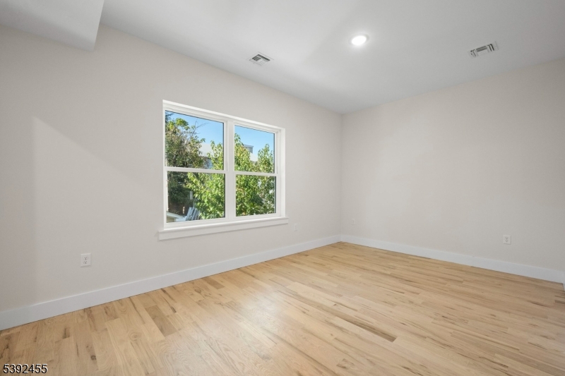 56 Second Street Elizabeth Port, NJ 07206 - Photo 7 of 28 an empty room with wooden floor and windows