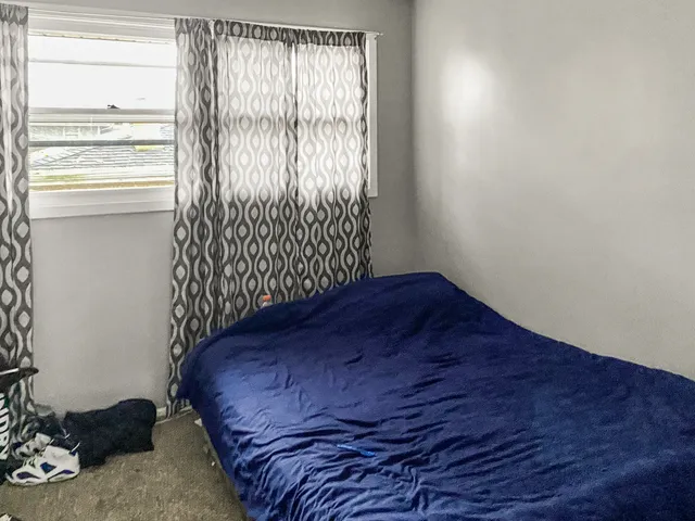 a bed sitting in a bedroom next to a window