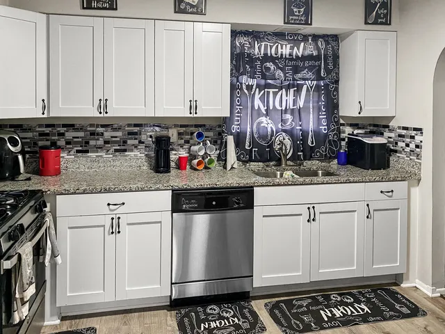 a kitchen with stainless steel appliances granite countertop a sink stove and cabinets