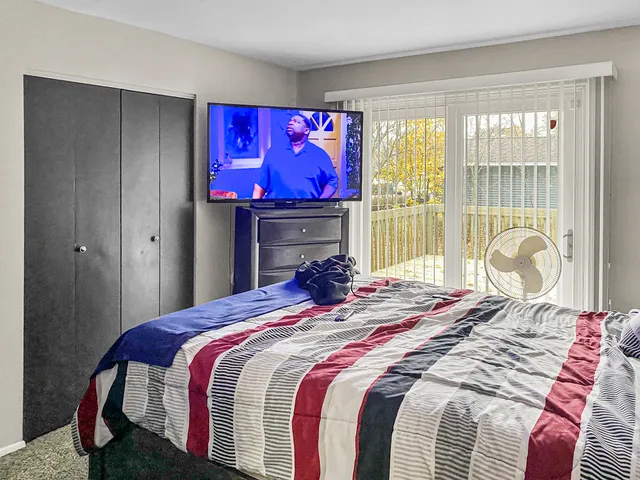 a bedroom with a bed a closet and mirror