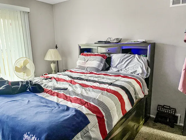 a bedroom with a bed and a lamp