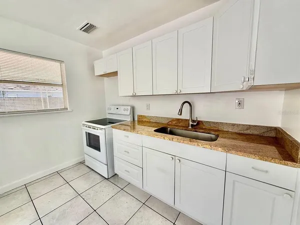 a kitchen with white cabinets sink and white appliances