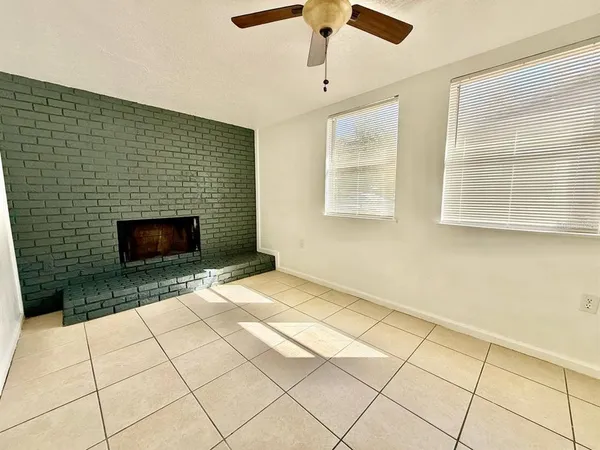 a view of an empty room with a fireplace and a window