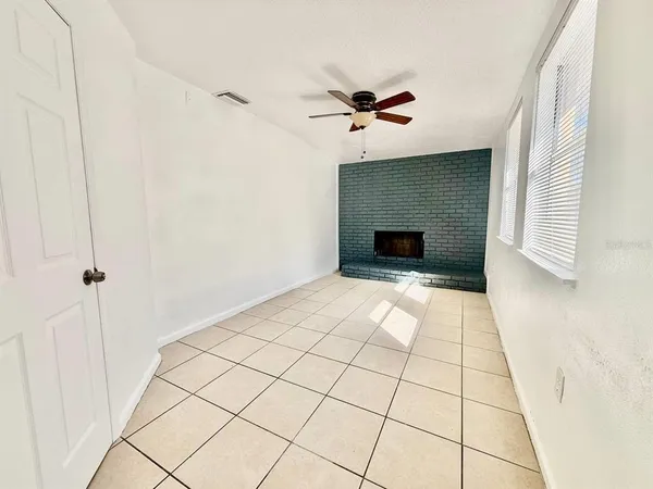 a view of empty room with window and ceiling fan