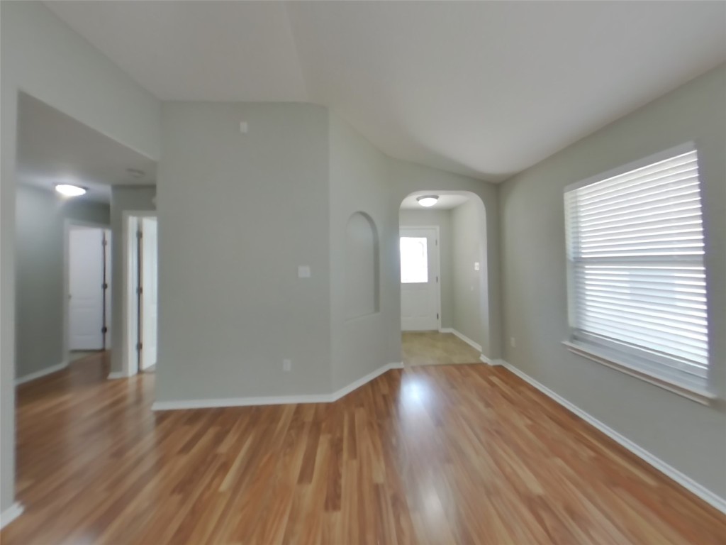 3106 Wickham Lane Austin, TX 78725 - Photo 2 of 16 a view of an empty room with wooden floor and a window