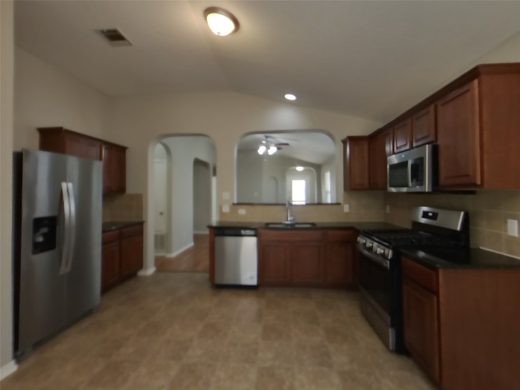 3106 Wickham Lane Austin, TX 78725 - Photo 5 of 16 a kitchen with stainless steel appliances granite countertop a refrigerator a stove a sink a microwave and a refrigerator
