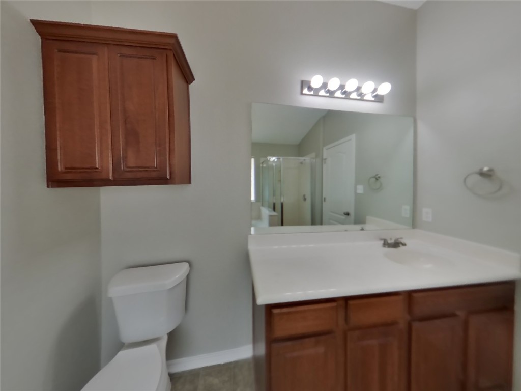 3106 Wickham Lane Austin, TX 78725 - Photo 9 of 16 a bathroom with a sink a toilet and a mirror