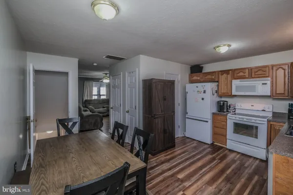 a kitchen with stainless steel appliances granite countertop a refrigerator a stove and a sink with wooden floor