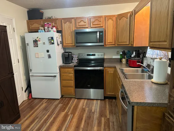 a kitchen with a refrigerator and a stove top oven