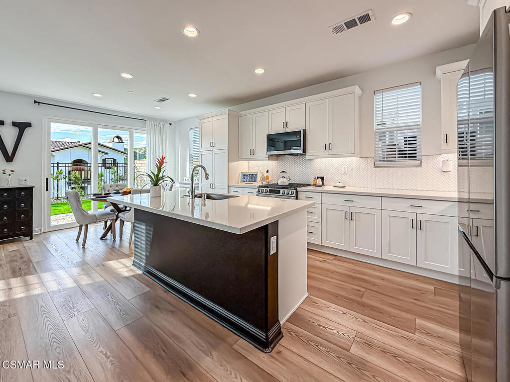 335 Fraser Camarillo, CA 93010 - Photo 1 of 75 a kitchen with stainless steel appliances granite countertop a stove top oven a sink dishwasher a dining table and chairs with wooden floor
