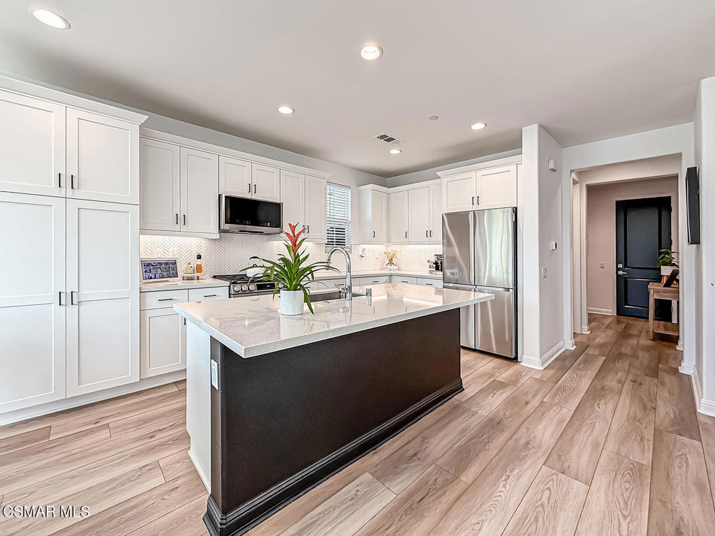 335 Fraser Camarillo, CA 93010 - Photo 12 of 75 a kitchen with stainless steel appliances granite countertop a refrigerator a sink dishwasher a stove and white countertops with wooden floor