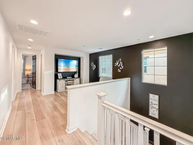 a large white room with kitchen island a sink a counter space and stainless steel appliances