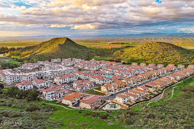 a kitchen with stainless steel appliances granite countertop a refrigerator a sink dishwasher a stove and white countertops with wooden floor