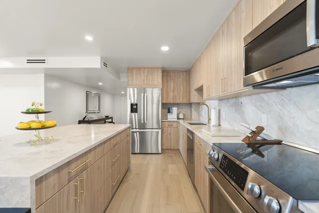 a kitchen with stainless steel appliances granite countertop a sink a stove and a refrigerator