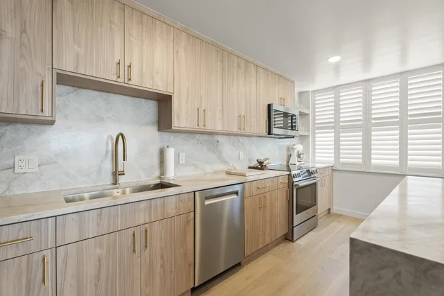 a kitchen with stainless steel appliances granite countertop a sink stove and cabinets