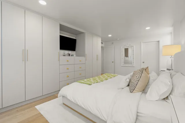 a spacious bedroom with a bed and a flat screen tv