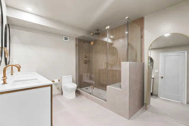 a bathroom with a double vanity sink toilet and shower