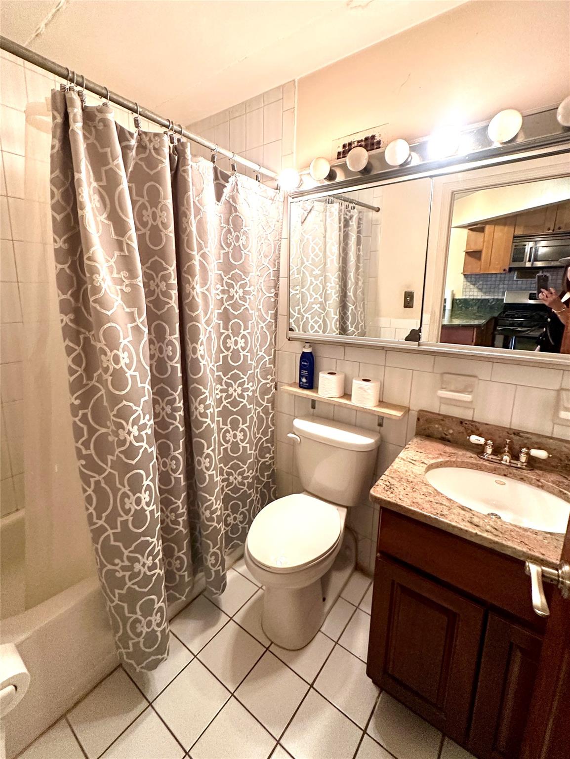 130-14 60th Avenue, Unit 2E Queens, NY 11355 - Photo 7 of 8 Bathroom with shower / bath combo with shower curtain, tile patterned flooring, vanity, and tasteful backsplash