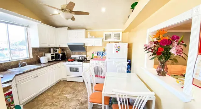 a kitchen with stainless steel appliances kitchen island granite countertop a sink cabinets and window