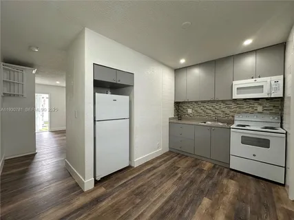 a kitchen with granite countertop white cabinets and white appliances