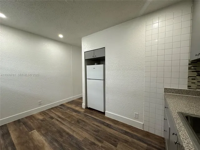 a view of empty room with wooden floor and fireplace