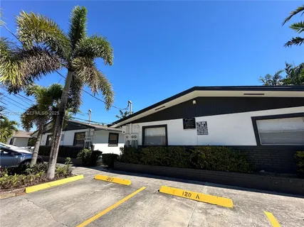 a view of a house with a yard and palm trees